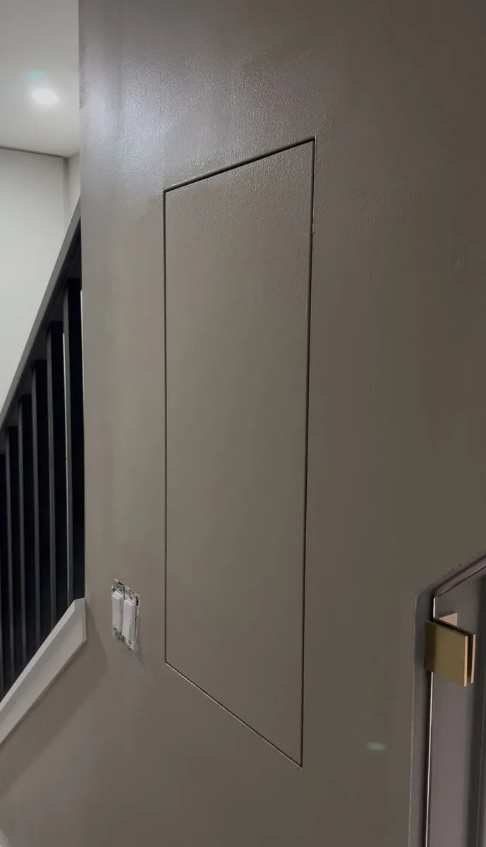 Finished hidden utility room door — panel blends seamlessly into decorative wall moulding