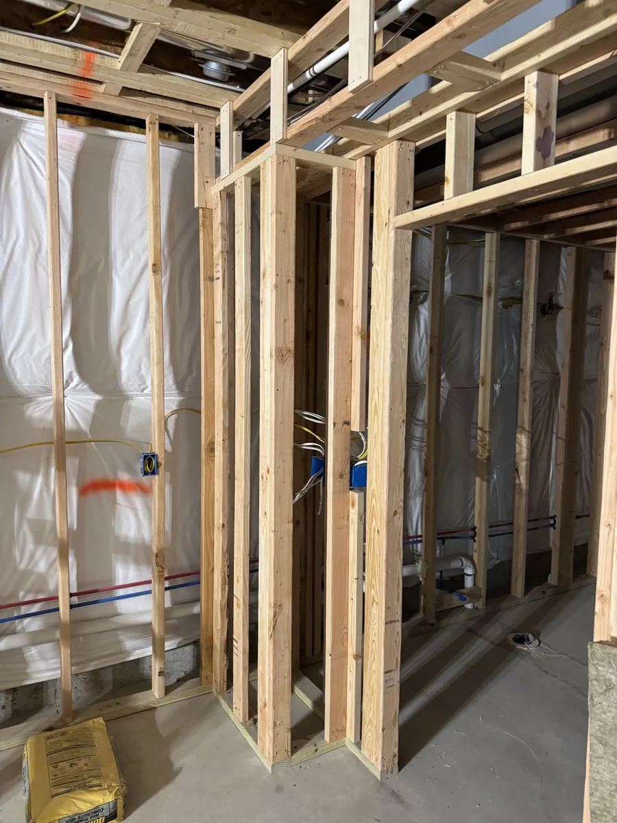 King of Prussia basement before renovation — raw lumber framing, exposed electrical wiring and plumbing