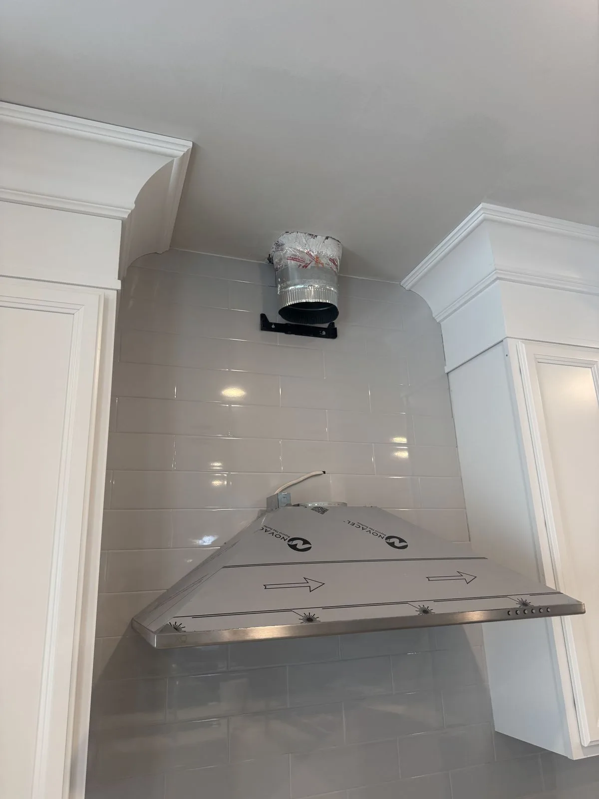 Range hood with original packaging visible during kitchen soffit installation — West Chester PA